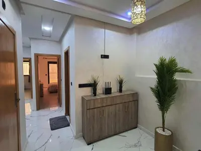 a room with a wooden cabinet and a potted plant at Meknes centre ville Appartement neuf moderne et bien équipé in Meknès