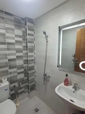a bathroom with a sink and a toilet and a mirror at Meknes centre ville Appartement neuf moderne et bien équipé in Meknès