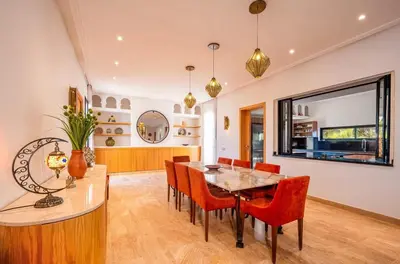 a dining room with a table and red chairs at Villa SUNSET Marrakech in Marrakech