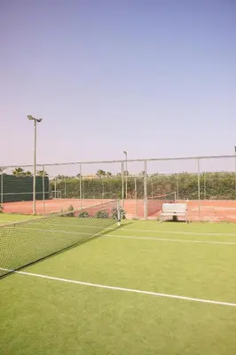 a tennis court with a net on a green court at Villa SUNSET Marrakech in Marrakech