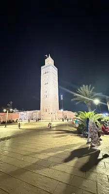a large building with a clock tower at night at Villa SUNSET Marrakech in Marrakech
