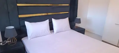 a bedroom with a bed with white sheets and pillows at Appartement azrou in Azrou