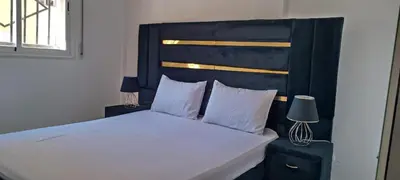 a bedroom with a large bed with a black headboard at Appartement azrou in Azrou