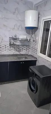 a kitchen with a washing machine and a sink at Appartement azrou in Azrou