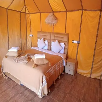 a bedroom with a bed in a tent at Unique Sahara Camp in Merzouga
