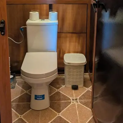 a bathroom with a toilet and a trash can at Unique Sahara Camp in Merzouga