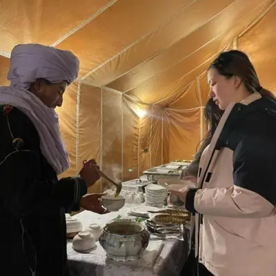 two women standing in a tent preparing food at Unique Sahara Camp in Merzouga
