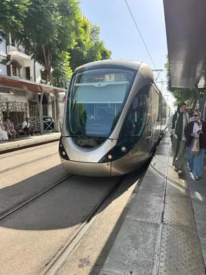 a train pulling into a station with people waiting on the platform at Appartement Rabat Agdal in Oulad Akkou
