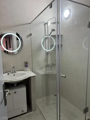 a bathroom with a shower and a sink and a mirror at Appartement Rabat Agdal in Oulad Akkou