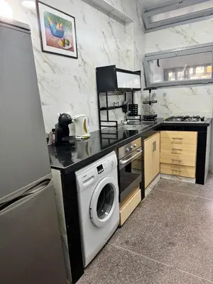 a kitchen with a washing machine and a washer at Appartement Rabat Agdal in Oulad Akkou