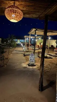 a pavilion with a table and a chandelier at night at Desert luxury in Merzouga