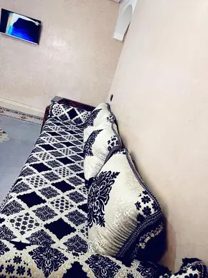 a bed with black and white pillows in a room at Bel appartement 2 chambres au cœur de Marrakech in Oulad Akkou
