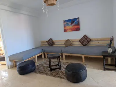 a living room with a blue couch and a table at Tayyurt Blue waves Beach house's in Oulad Akkou