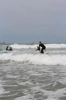 a man riding a wave on a surfboard in the ocean at Tayyurt Blue waves Beach house's in Oulad Akkou