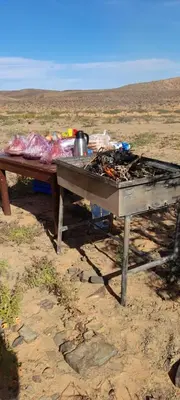 a picnic table in the middle of a field at Camel desert camp in Merzouga