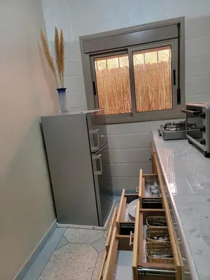a kitchen with a counter with an open refrigerator at Blue Palm apartment in Ouarzazate