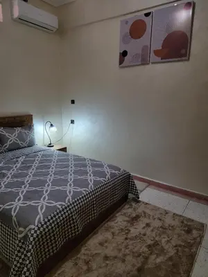 a bedroom with a bed and a picture on the wall at Blue Palm apartment in Ouarzazate