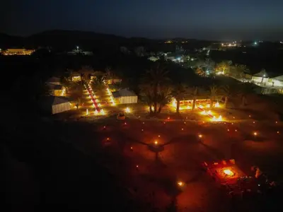 an aerial view of a park at night with lights at Sahara Experience Luxury Camp in Merzouga