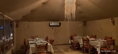 a dining room with tables and chairs and a chandelier at Sahara Experience Luxury Camp in Merzouga