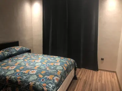 a bedroom with a bed with a floral comforter at Apartement in saada fez in Fès