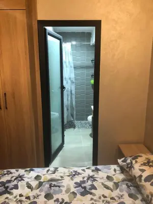 a bedroom with a bed and a bathroom with a shower at Apartement in saada fez in Fès