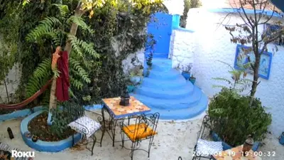 a patio with a table and chairs next to the water at Gite montana in Aïn Leuh