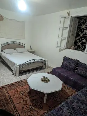 a bedroom with a bed and a table and a couch at Gite montana in Aïn Leuh