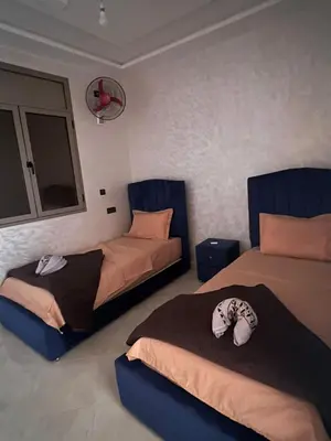 a bedroom with two beds and a mirror at Sahara Luxury Apartments in Hassilabied