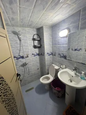 a bathroom with a toilet and a sink at Sahara Luxury Apartments in Hassilabied
