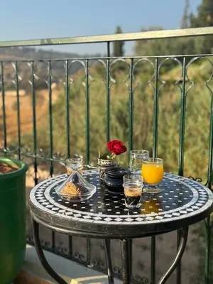 a table with a tray of food and drinks on a balcony at Riad Citronnier & Spa in Fès