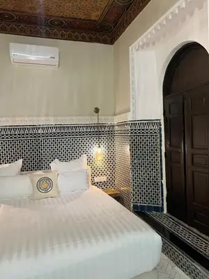 a bedroom with a bed and a black door at Riad Citronnier & Spa in Fès