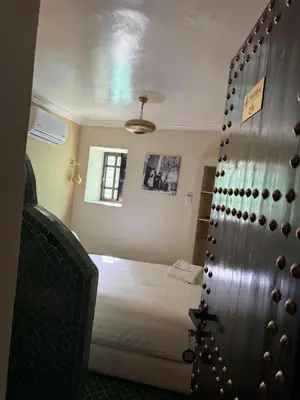 a bedroom with a bed and a closet with a door at Riad Citronnier & Spa in Fès