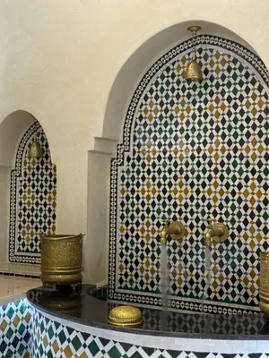 a moroccan bathroom with a moroccan patterned wall and a table at Riad Citronnier & Spa in Fès