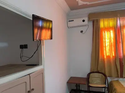 a room with a television and a bed and a table at COMPLEXE TOURISTIQUE ARTIZANAL bab sahara in Oulad Akkou
