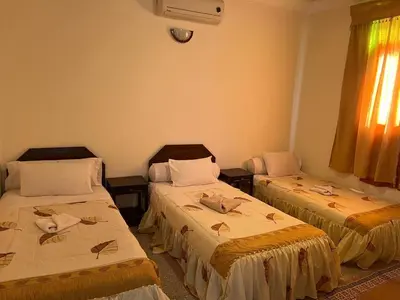 a room with two beds and a window at COMPLEXE TOURISTIQUE ARTIZANAL bab sahara in Oulad Akkou