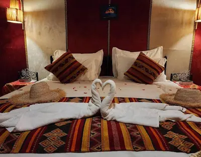two swans making a heart on a bed at irrigation desert camp in Merzouga