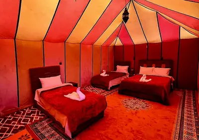 a room with two beds in a tent at irrigation desert camp in Merzouga