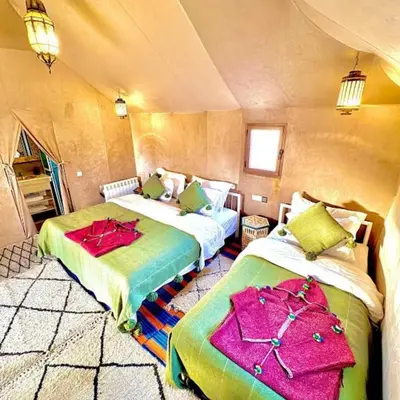 a room with two beds in a tent at irrigation desert camp in Merzouga
