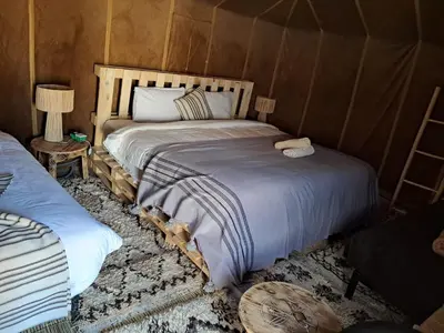 a bedroom with a bed in a tent at Slik Sand Oasis Camp in Merzouga