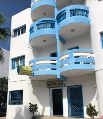 a building with blue balconies on the side of it at Restinga in Oulad Akkou