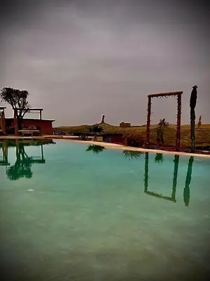 a large pool of blue water next to at Les Bedouins Agafay in Oulad Akkou