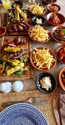 a table with many plates of food on it at Les Bedouins Agafay in Oulad Akkou