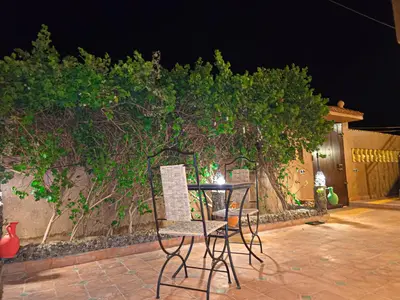 a table and chairs on a patio at night at Dar Dallali in Mhamid