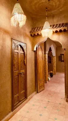 a hallway with two wooden doors in a building at Dar Dallali in Mhamid