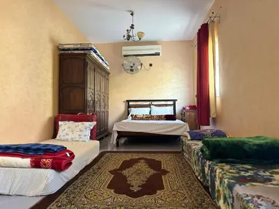 a living room with two beds and a couch at Maison Merzouka - Rustic Stay in the Taza Countryside