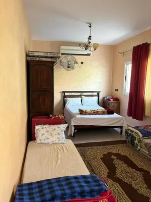a bedroom with a bed and a couch at Maison Merzouka - Rustic Stay in the Taza Countryside