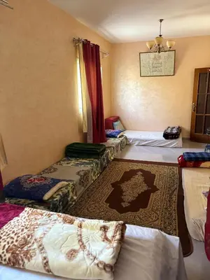 a room with three beds and a rug at Maison Merzouka - Rustic Stay in the Taza Countryside