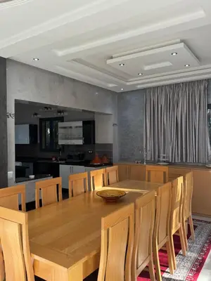 a dining room and kitchen with a wooden table and chairs at Dar Jabal in Aït Zat