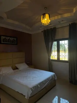 a bedroom with a bed and a chandelier and a window at Dar Jabal in Aït Zat