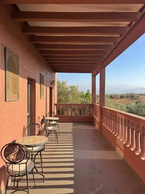 a balcony with tables and chairs on a building at Dar Jabal in Aït Zat